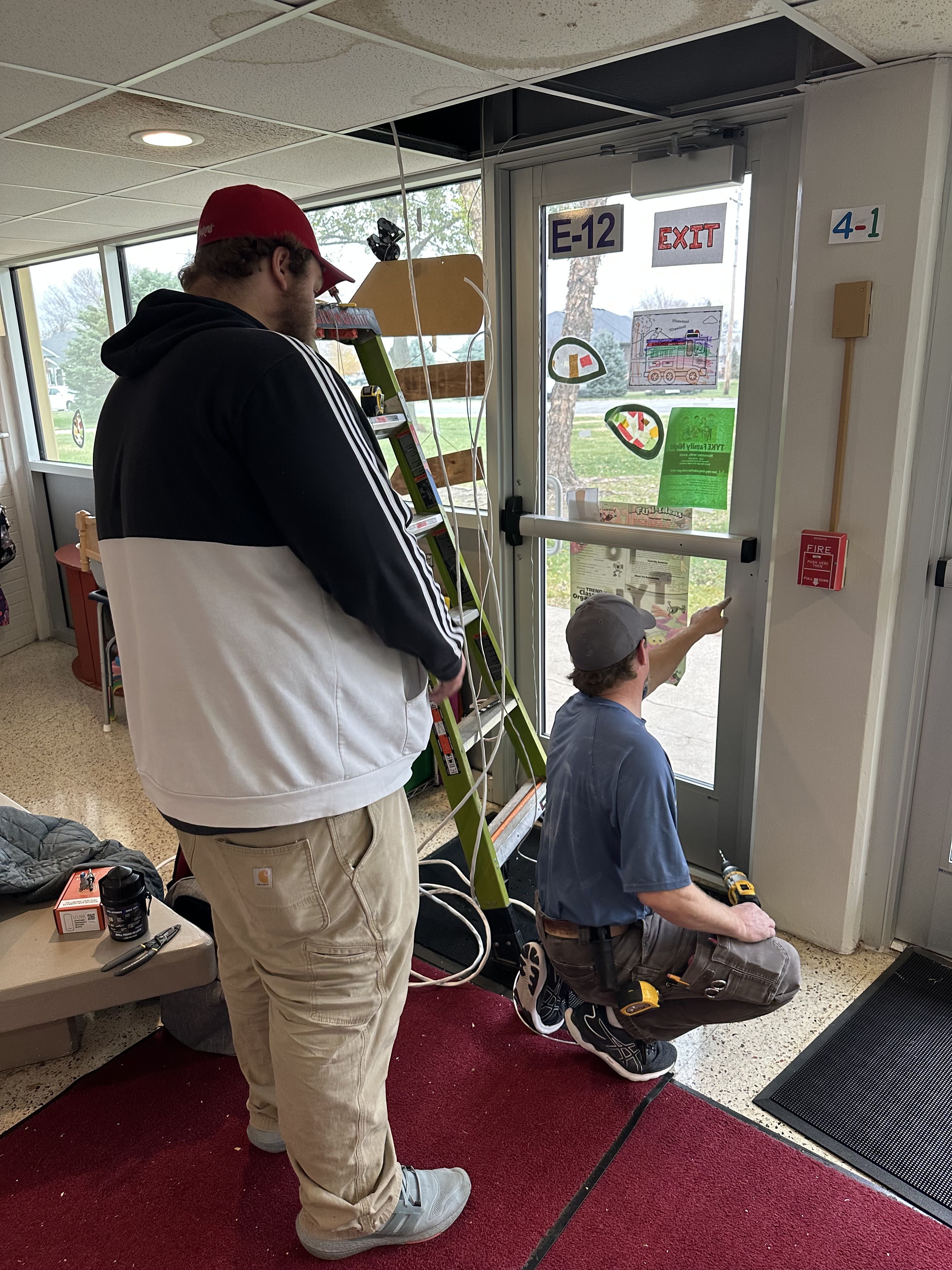 man showing technician how to wire door access control system