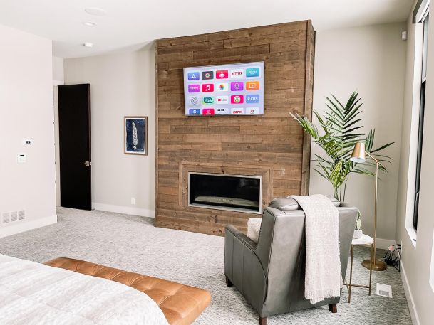 Bedroom TV hanging in wooden accent wall
